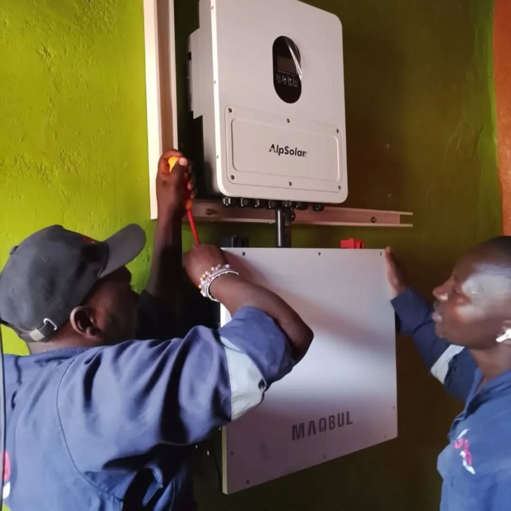 Delta Power Links technicians installing the AlpSolar inverter and battery